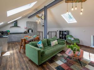 a living room with a green couch and a kitchen at 2 Bed in High Bickington 49558 in High Bickington