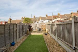 a backyard with a fence and green grass at Rochester Slopes - Free Street Parking in Strood