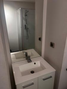 a white bathroom with a sink and a mirror at EFA in Villeurbanne