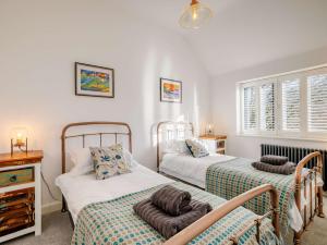 Cet hébergement comprend 2 lits dans une chambre dotée de murs blancs et de fenêtres. dans l'établissement 3 Bed in Dolgellau 90805, à Llanelltyd