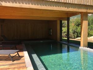 a swimming pool under a wooden pavilion at Calma Sur Hoteleria Boutique in Lago Meliquina