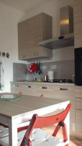 une cuisine avec une table et une chaise rouge dans l'établissement Tigullio Vacations, à Leivi