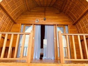 - une chambre avec une grande fenêtre dans une maison en bois dans l'établissement Suwehan Beach Cliff House by BIJAK, à Polilit