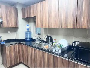 a kitchen with a sink and a microwave at Executive Master Bedroom In Shared Apartment in Dubai