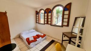um quarto com uma cama e duas janelas em Coliving Stela Mares em Florianópolis