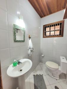 Baño blanco con lavabo y aseo en Casa para temporada em Ilhabela, en Ilhabela