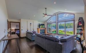 a living room with two couches and a large window at Four Season Waterfront Muskoka Retreat in Bracebridge