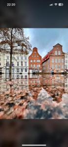 een reflectie van gebouwen in een plas water bij Innenstadt Lübeck Ferienwohnung in Lübeck
