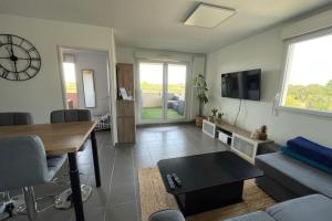 uma sala de estar com uma mesa e um relógio na parede em Le Panoramique- Air conditioning terrace and parking! em Saint-Brès