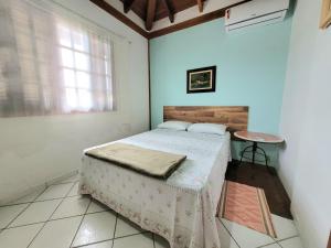 Un dormitorio con una cama y una mesa. en Casa para temporada em Ilhabela, en Ilhabela
