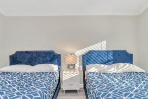 two beds sitting next to each other in a bedroom at Modern Accessible Houston Gem Jacuzzi & Air Hockey 6Beds in Houston