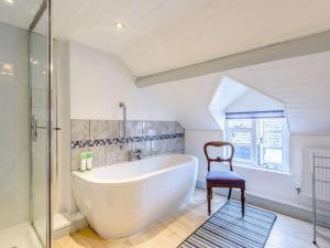 a bathroom with a large tub and a chair at 1 Bed in Presteigne 53667 in Presteigne