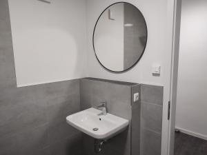 La salle de bains est pourvue d'un lavabo et d'un miroir. dans l'établissement Valley of Business Frankfurt-West - Studio Apartment, à Hofheim am Taunus