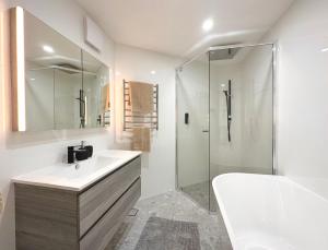 a white bathroom with a sink and a shower at Full Circle Apartments in Jindabyne