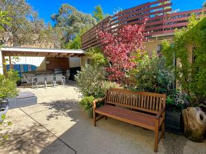 a wooden bench sitting in front of a building at Full Circle Apartments in Jindabyne