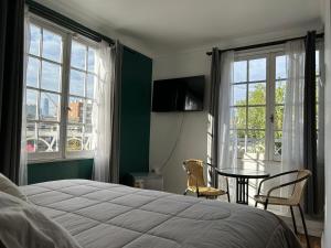 1 dormitorio con cama, mesa y ventanas en Casa Di Patti en Santiago