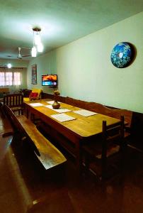 a dining room with a wooden table and chairs at Casa Yvy Pytã in Puerto Iguazú