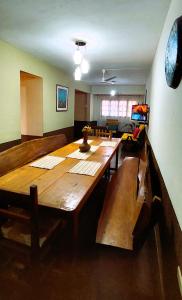 a living room with a large wooden table and benches at Casa Yvy Pytã in Puerto Iguazú