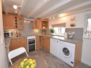 a kitchen with wooden cabinets and a table with a bowl of fruit at 2 bed in Wells 52STT in Wells