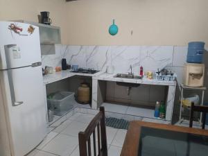 una pequeña cocina con nevera y fregadero en Casa na praia Lucena para alugar por temporada, en Lucena