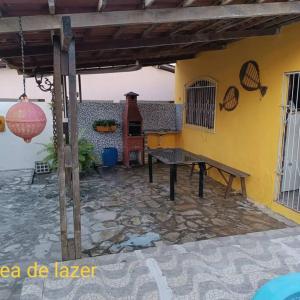 a patio of a house with a wooden table at Casa na praia Lucena para alugar por temporada in Lucena
