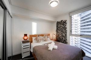 a bedroom with a large bed and a window at Prime location - CBD Brisbane 1 bed w shared 25m pool, gym, sundeck and a BBQ area in Brisbane