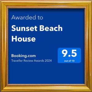 een ingelijste foto van een strandhuis bij zonsondergang bij Sunset Beach House in Chatan