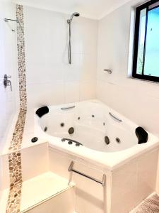 a white bath tub in a bathroom with a window at Full Circle Apartments in Jindabyne