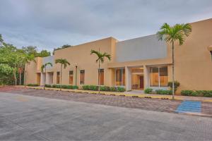 a building with palm trees in front of it at City Express by Marriott Playa del Carmen in Playa del Carmen