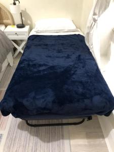 una coperta blu su un letto in una camera da letto di Sydney Olympic Park Half House - All Yours a Sydney