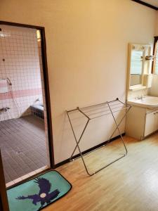 ein Bad mit einer Dusche und einer Glastür in der Unterkunft 鷹とあそべる海辺のカフェ&ゲストハウスことひ 