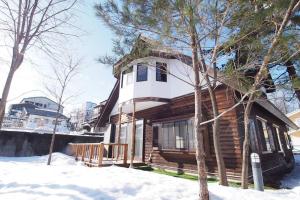 a wooden house in the snow with trees at お湯掛け流し『草津温泉湯畑』徒歩圏内※温泉街を大勢で遊びたい & 癒されたい in Kusatsu