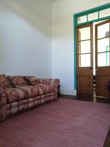 un sofá sentado en una habitación con puerta en Departamento Independiente en Casa Patrimonial en Vicuña