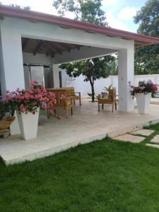a pavilion with benches and flowers in a yard at Villa Grecko Place in Jarabacoa