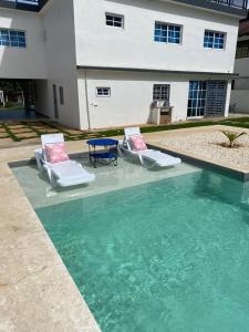 two chairs and a table in a swimming pool at Villa Grecko Place in Jarabacoa