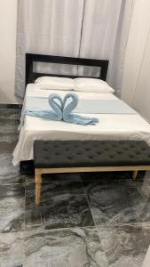 a bed with a blue ribbon on top of it at Villa Grecko Place in Jarabacoa