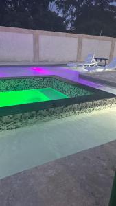 a swimming pool with a green and purple lighting at Villa Grecko Place in Jarabacoa