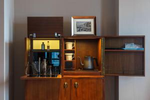 a wooden cabinet with a coffee maker and wine glasses at Maxx by Steigenberger on the Bund Shanghai in Shanghai