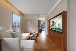 a living room with a white couch and a tv at Maxx by Steigenberger on the Bund Shanghai in Shanghai