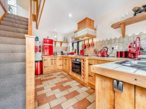 a large kitchen with wooden cabinets and red appliances at The Apartment - Uk45103 in Hoel-galed