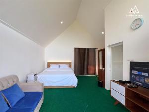 a bedroom with a bed and a couch and a tv at Ciater Dream Village in Cicadas