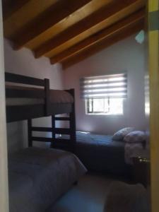 a bedroom with two bunk beds and a window at cabaña valdivia 2 in Valdivia