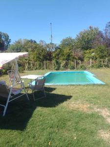 a swimming pool with two chairs and an umbrella at Cabañas en Valdivia in Valdivia