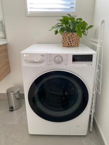 a washing machine with a plant on top of it at Lake Views - new apartment with room to relax in Wanaka