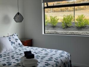 a bedroom with a bed and a large window at Lake Views - new apartment with room to relax in Wanaka