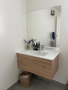 a bathroom with a sink and a mirror at Lake Views - new apartment with room to relax in Wanaka