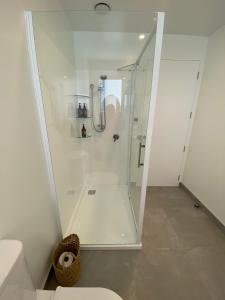 a shower with a glass door in a bathroom at Lake Views - new apartment with room to relax in Wanaka