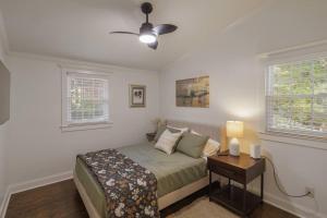 a bedroom with a bed and a nightstand and two windows at 2BR 2Bath Chamblee Brookhaven Ashford Park Brand new furnishings throughout in Atlanta