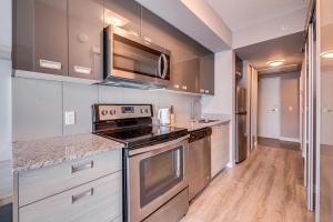 uma cozinha com electrodomésticos em aço inoxidável e pisos em madeira em 1 Bedroom Condo in Waterloo em Waterloo
