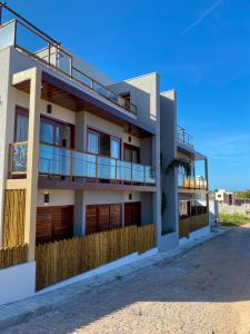 a building with balconies on the side of it at Villa Palmeira Flecheiras 202 in Flecheiras